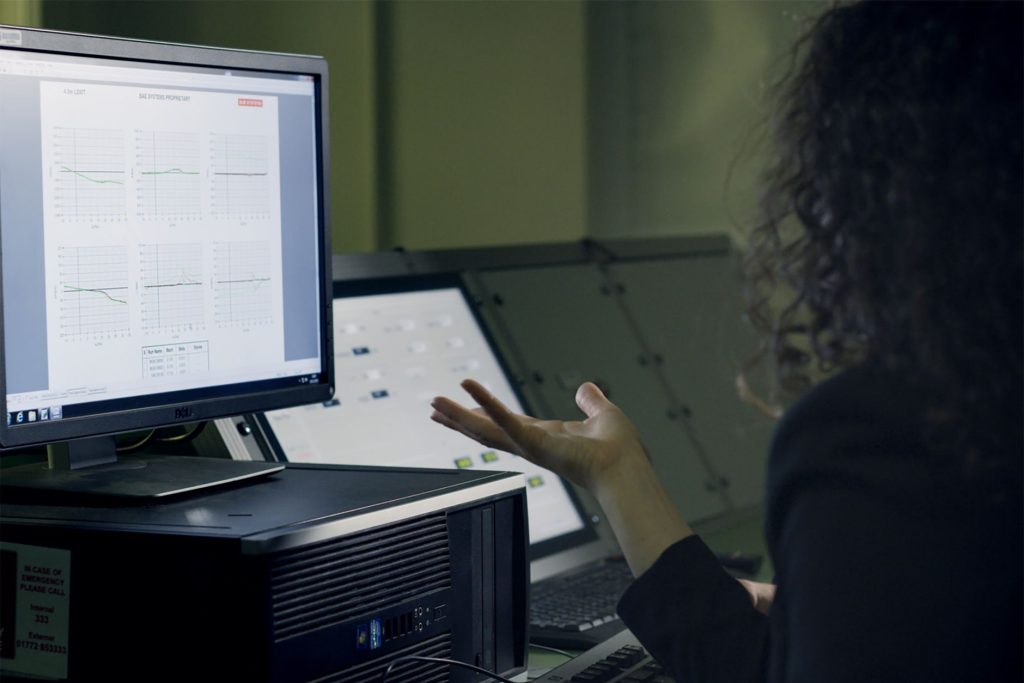 An engineer reviewing a 3D digital human simulation on a computer screen for ergonomic evaluation