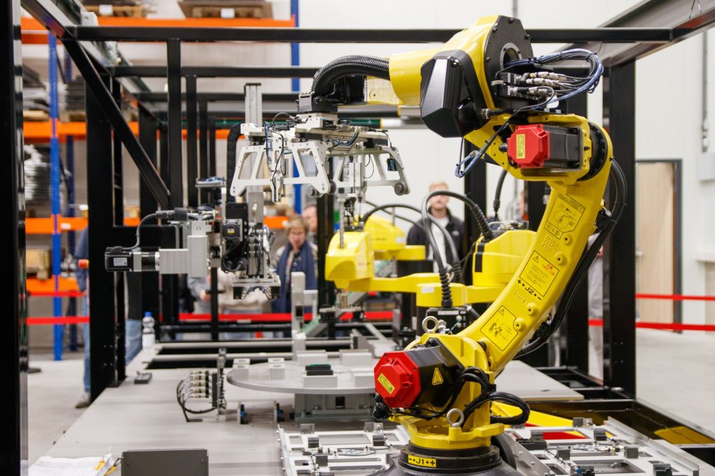 A digital throughput dashboard overlooking a modern factory assembly line, helping manufacturers monitor production output and accelerate throughput.