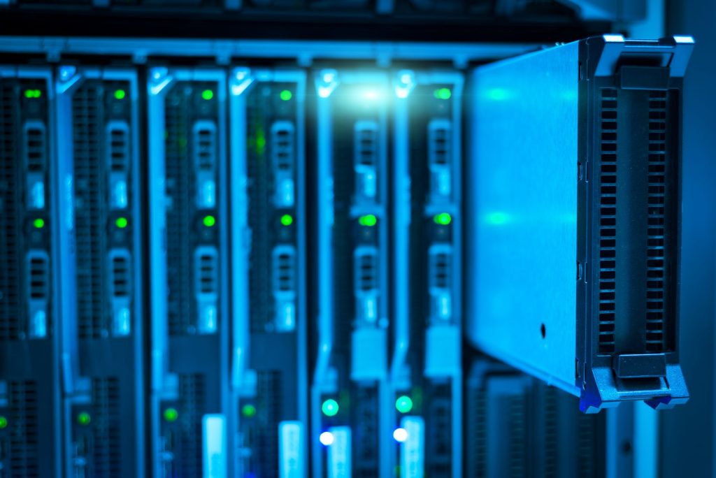 A technician monitors a hybrid AI setup on a tablet in front of local server racks, combining on-premises control with cloud scalability.