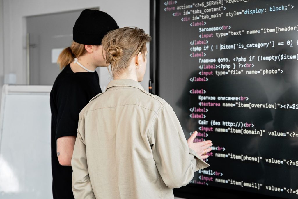 A professional explaining distributed system diagrams on a glass whiteboard to a technical team.
