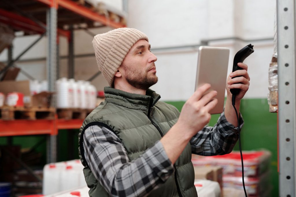 Shop owner checks inventory recommendations alongside stocked shelves.
